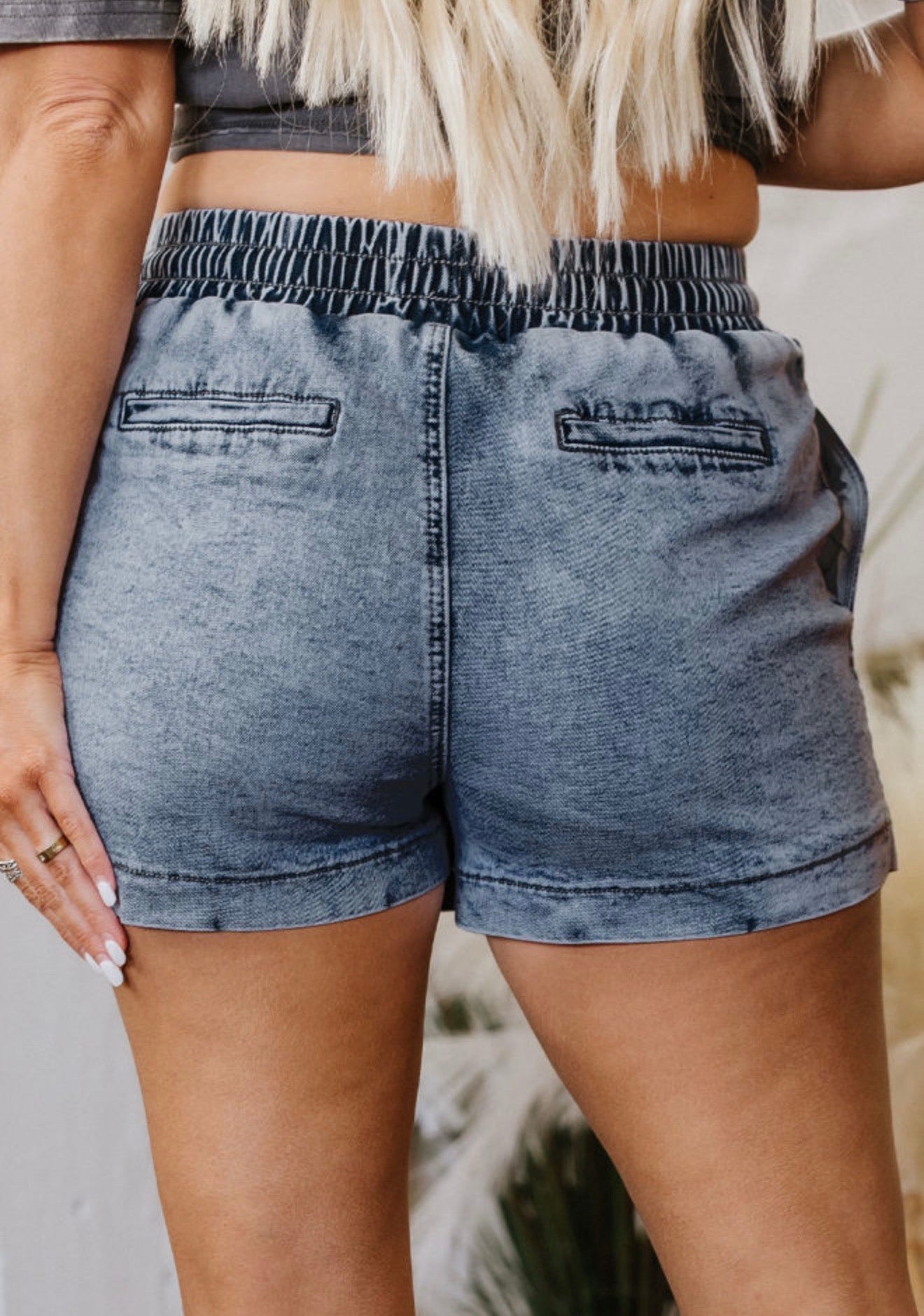 Ivy's Gifts & Boutique ML25 denim skirt shorts with elastic drawstring waist and small hem splits, shown on a model.