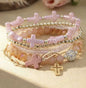Set of five pink and gold cross stackable bracelets by Ivy's Gifts & Boutique, featuring stylish jewelry with cross charms.