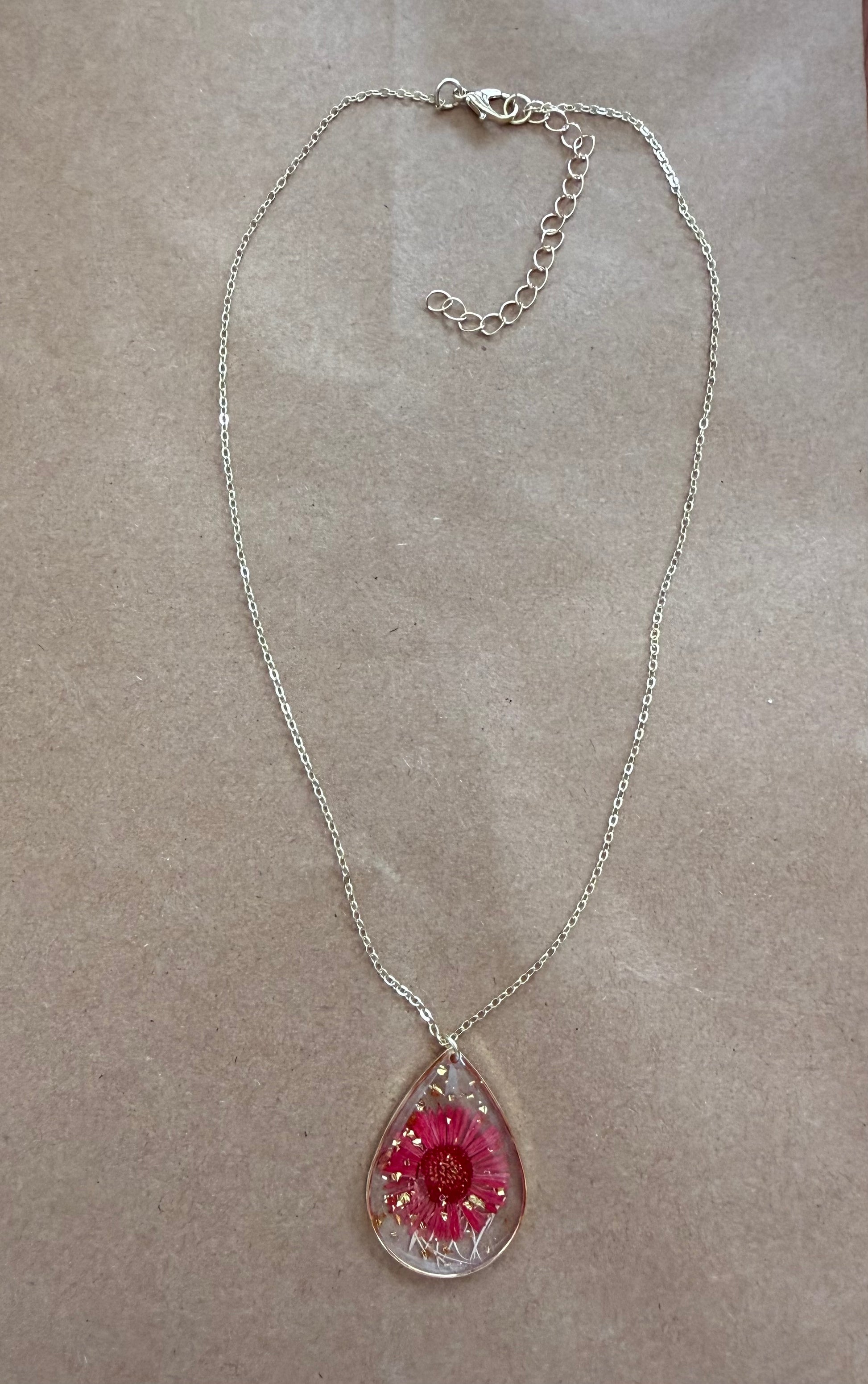 Dried flower pendant necklace with a silver chain from Ivy's Gifts & Boutique, showcasing a delicate floral design.