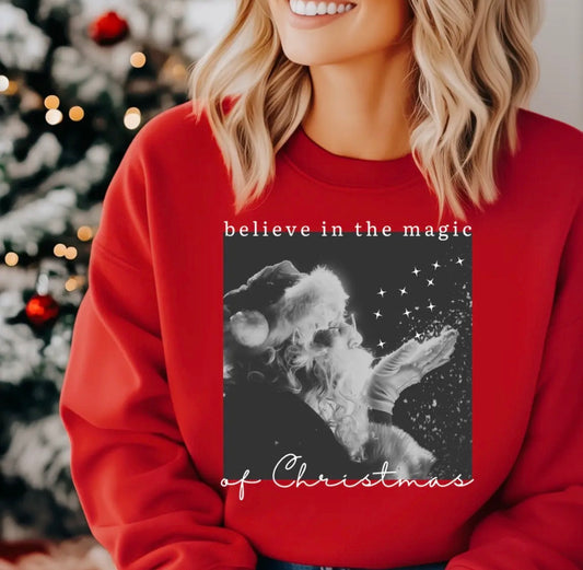 Bright red Christmas sweatshirt from Ivy's Gifts & Boutique featuring festive "Believe in the Magic of Christmas" design.