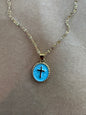 Enamel cross necklace from Ivy's Gifts & Boutique featuring a colorful, detailed religious pendant on a chain.