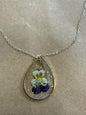Dried flower pendant necklace featuring a delicate floral design on a silver chain by Ivy's Gifts & Boutique.