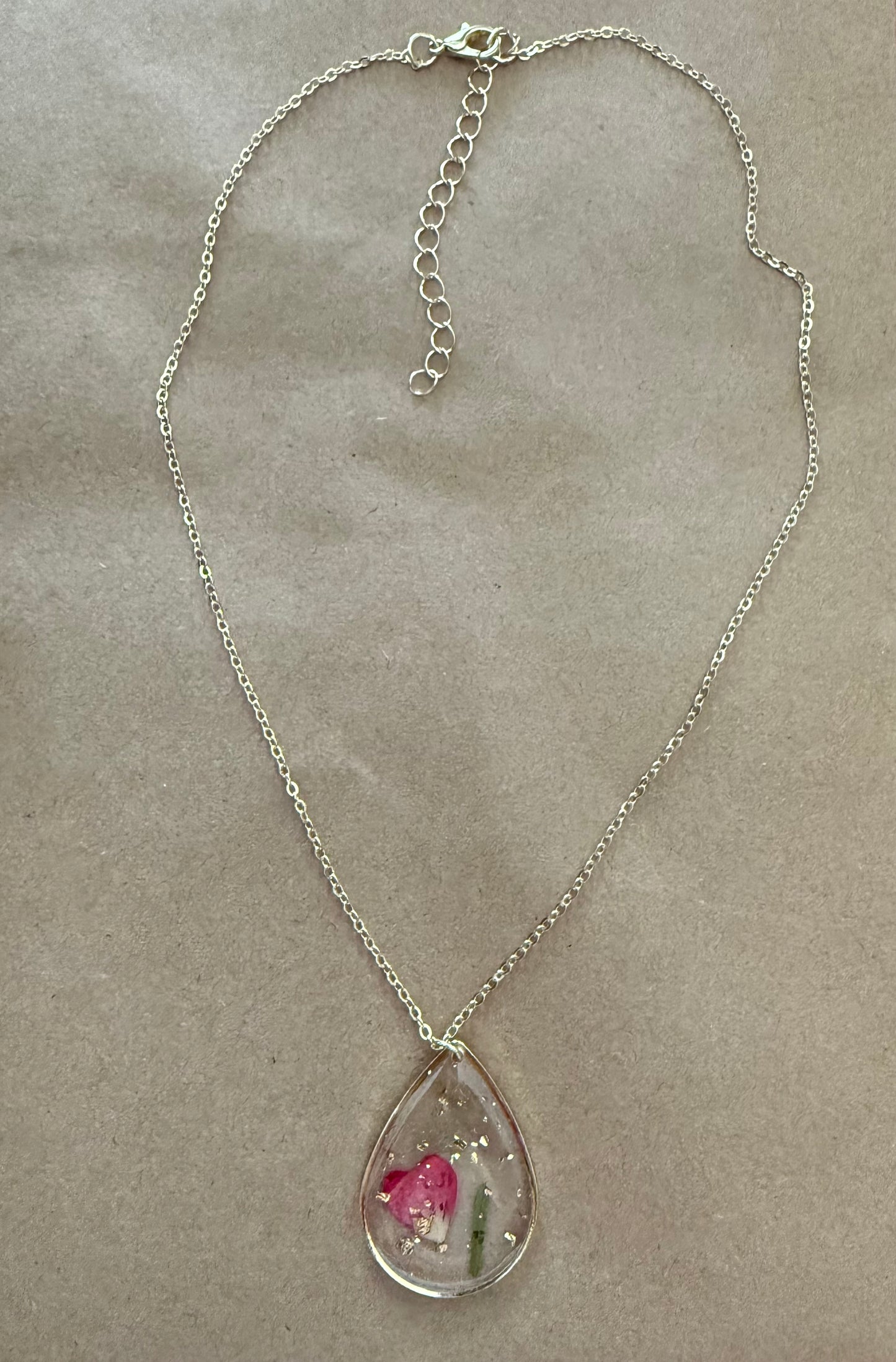 Dried flower pendant necklace from Ivy's Gifts & Boutique featuring a delicate floral design on a silver chain.