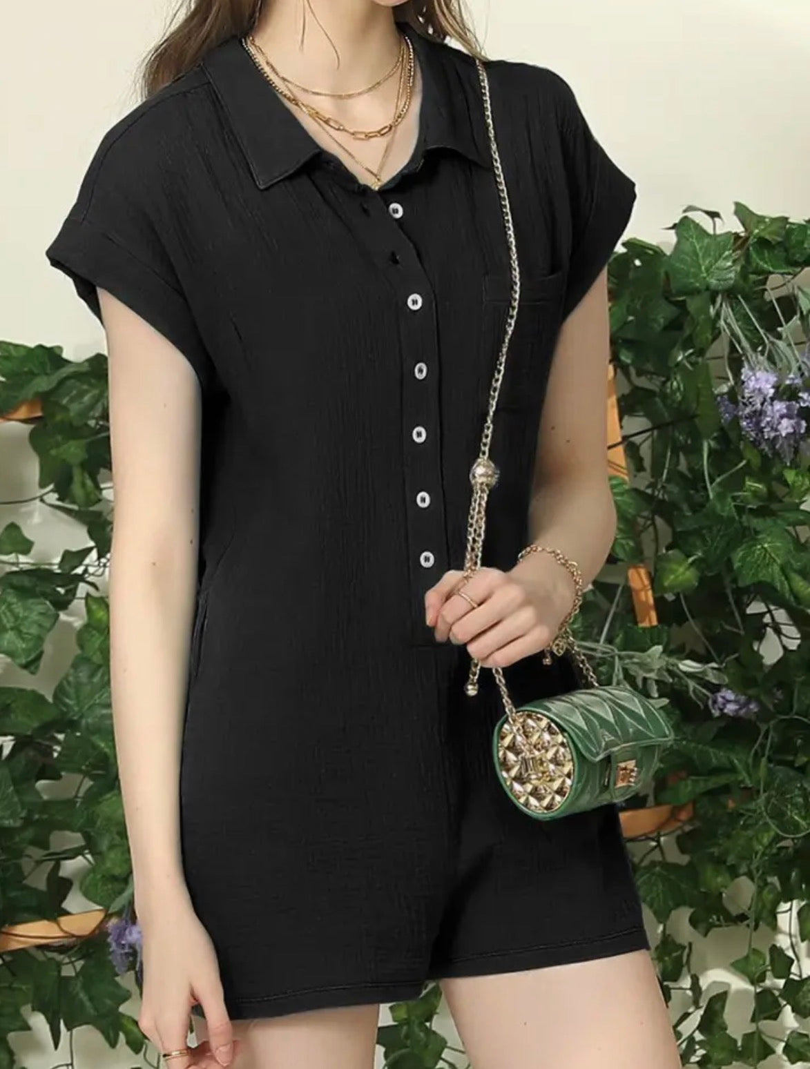 Black romper by Ivy's Gifts & Boutique featuring short sleeves, button front, and wide short legs, shown on a hanger.