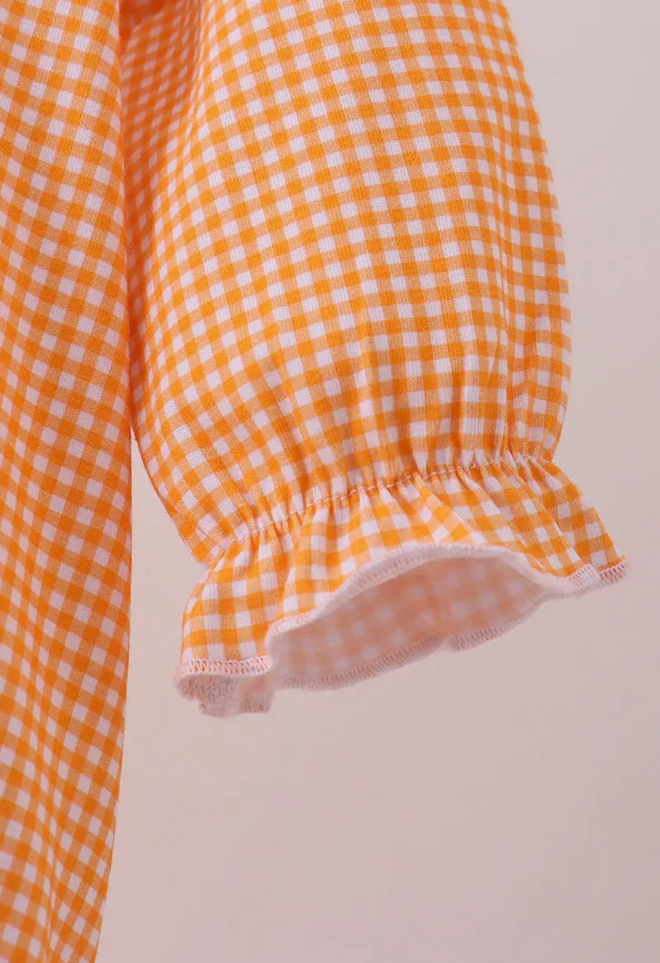 Long sleeve orange and white gingham bubble with embroidery from TN4 Premium by Ivy's Gifts & Boutique, shown on a child.
