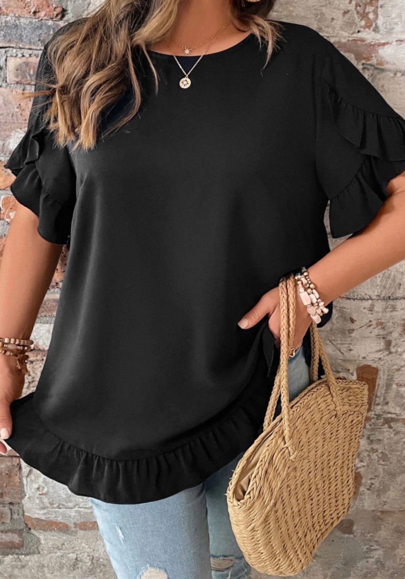 Black ruffle petal sleeve and hem top with tie back closure from Ivy's Gifts & Boutique, shown on a model.