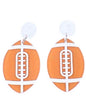 Orange and white acrylic football earrings with silver hooks, featuring a sporty design from Ivy's Gifts & Boutique.