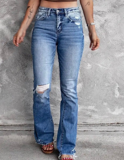 Distressed blue jeans with flare leg and frayed hem from Ivy's Gifts & Boutique, showcasing trendy casual denim style.