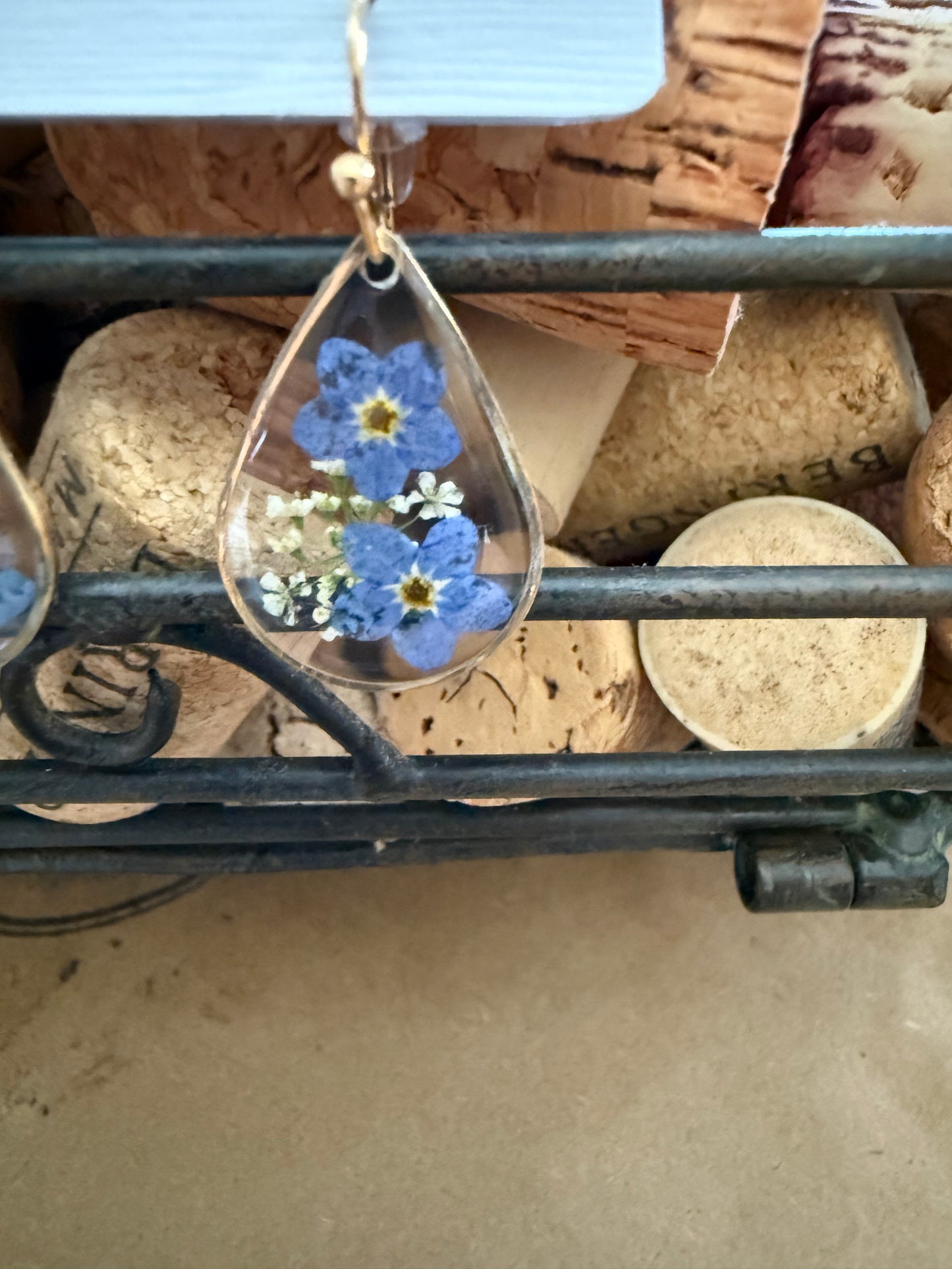 Dried flower earrings by Ivy's Gifts & Boutique featuring delicate pressed flowers on silver hooks.