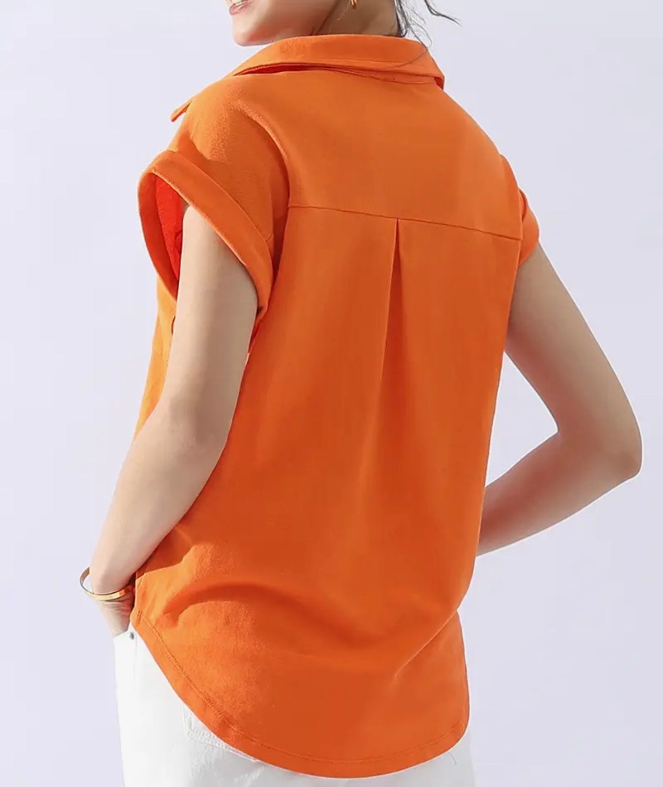 Orange cotton collar shirt with half button neck and front pocket from Ivy's Gifts & Boutique, displayed on a hanger.