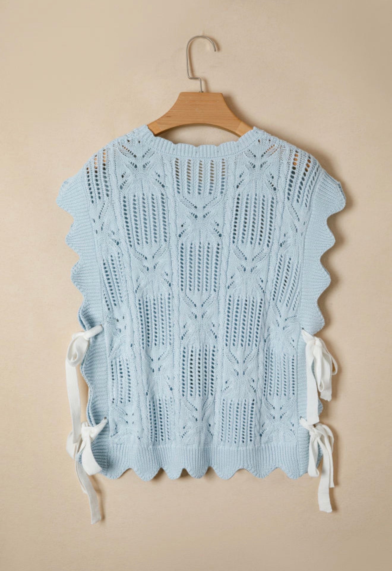 Light blue summer sweater with side tie accents from Ivy's Gifts & Boutique, shown on a hanger against a plain background.