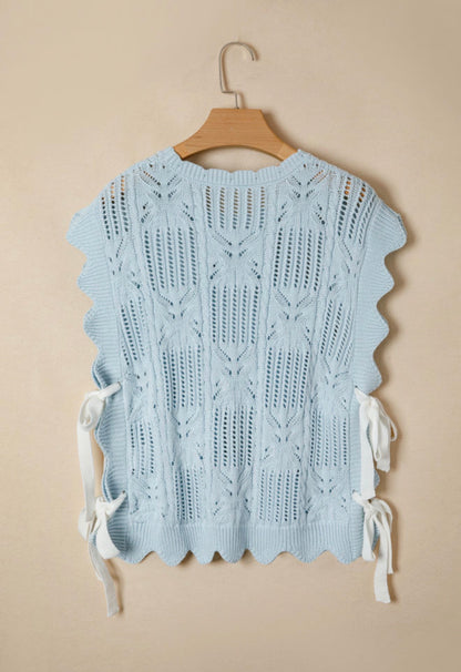 Light blue summer sweater with side tie accents from Ivy's Gifts & Boutique, shown on a hanger against a plain background.