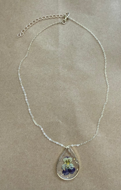 Dried flower pendant necklace with a gold chain, featuring a clear glass globe with preserved flowers, from Ivy's Gifts & Boutique.
