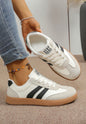 Black and white Ivy's Gifts & Boutique sneakers with sporty stripe design, featuring stylish laces and a comfortable athletic sole.