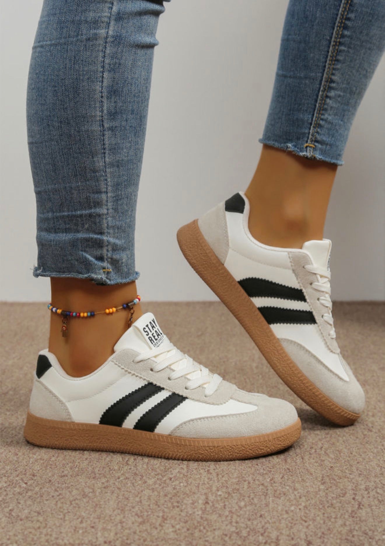 Black and white sneakers with sporty stripe from Ivy's Gifts & Boutique, showcasing a stylish, casual athletic shoe design.