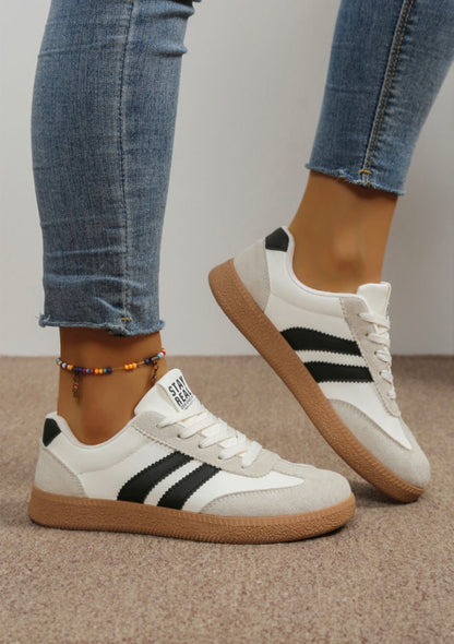 Black and white sneakers with sporty stripe from Ivy's Gifts & Boutique, showcasing a stylish, casual athletic shoe design.