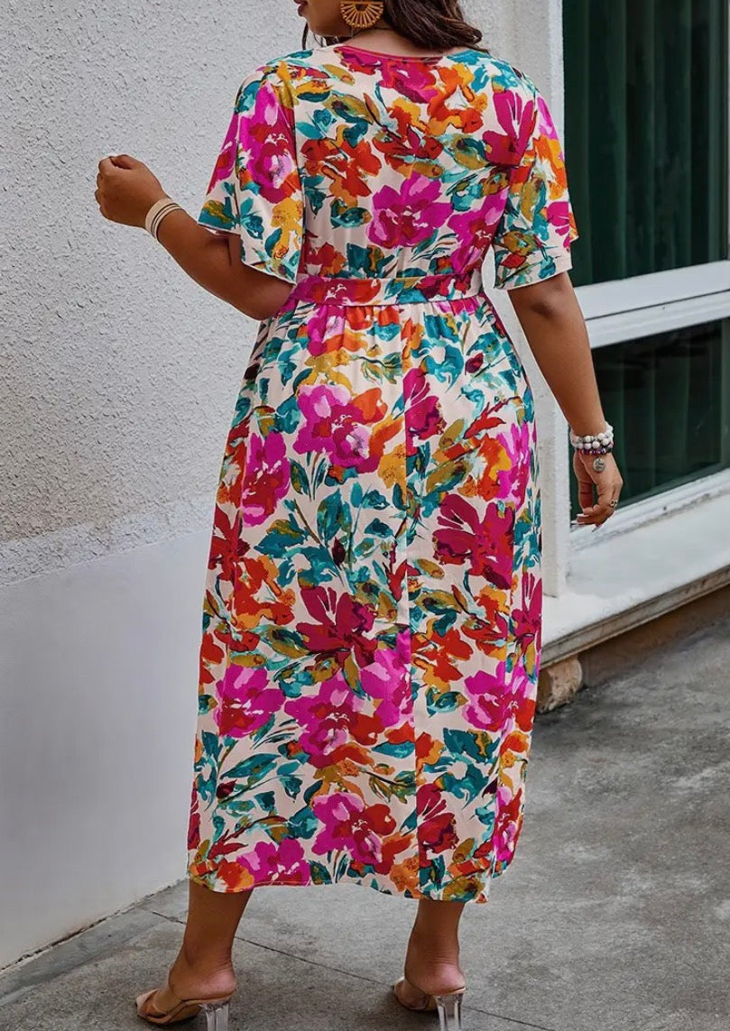 Floral printed dress by Ivy's Gifts & Boutique, featuring vibrant colors and a flowing silhouette on a mannequin.