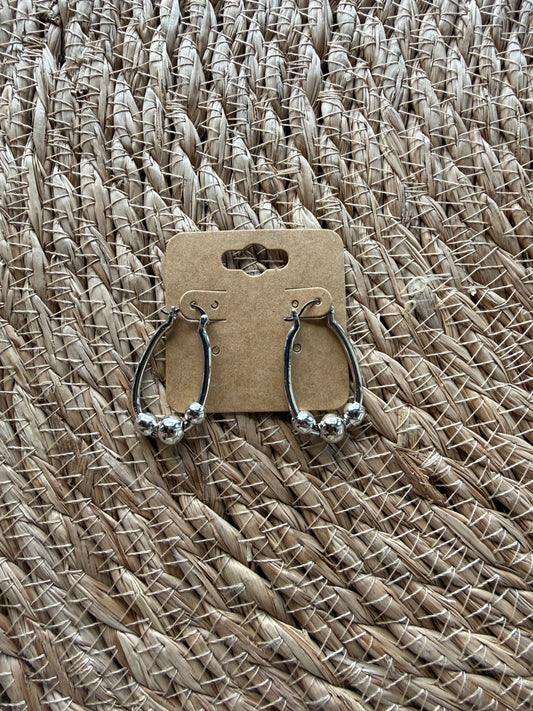 J1 silver earrings by Ivy's Gifts, featuring a sleek design with shimmering finish, elegantly displayed on a white background.