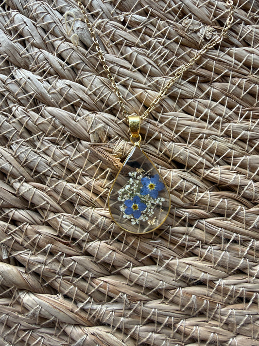 Blue dried flower necklace by Ivy's Gifts & Boutique, featuring delicate flowers set in a stylish pendant.
