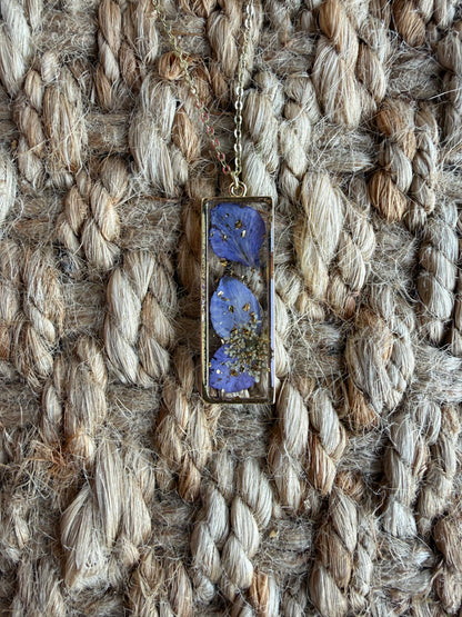 Purple dried flower pendant necklace featuring a delicate floral design on a silver chain by Ivy's Gifts & Boutique.