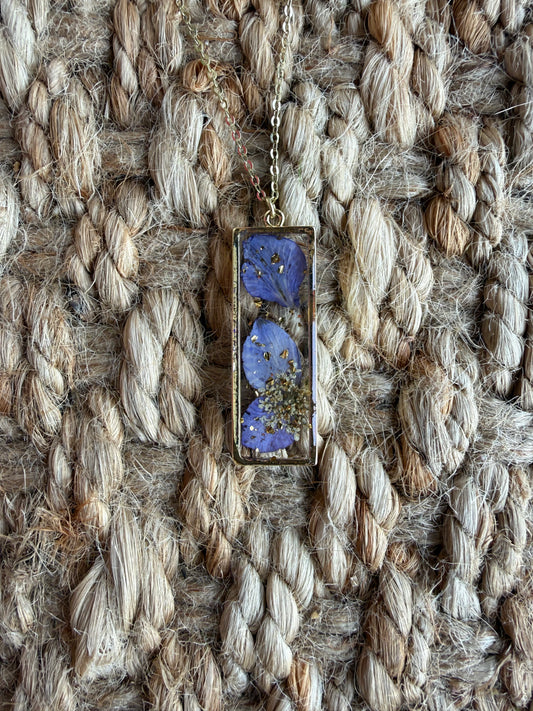 Purple dried flower pendant necklace featuring a delicate floral design on a silver chain by Ivy's Gifts & Boutique.